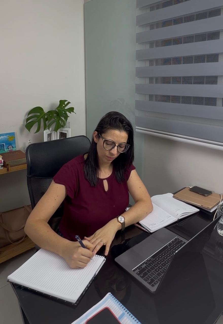 Thais trabalhando em casa, com seu caderno e computador
